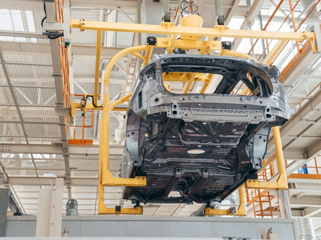 Zavěšená karoserie automobilu na automatizované montážní lince v automobilovém závodě.